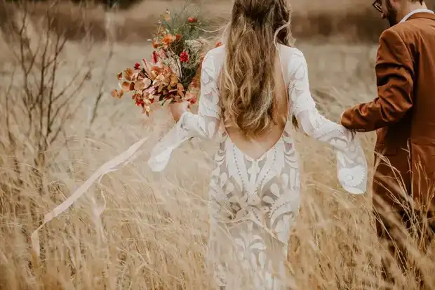 Couple walking in field during elopement